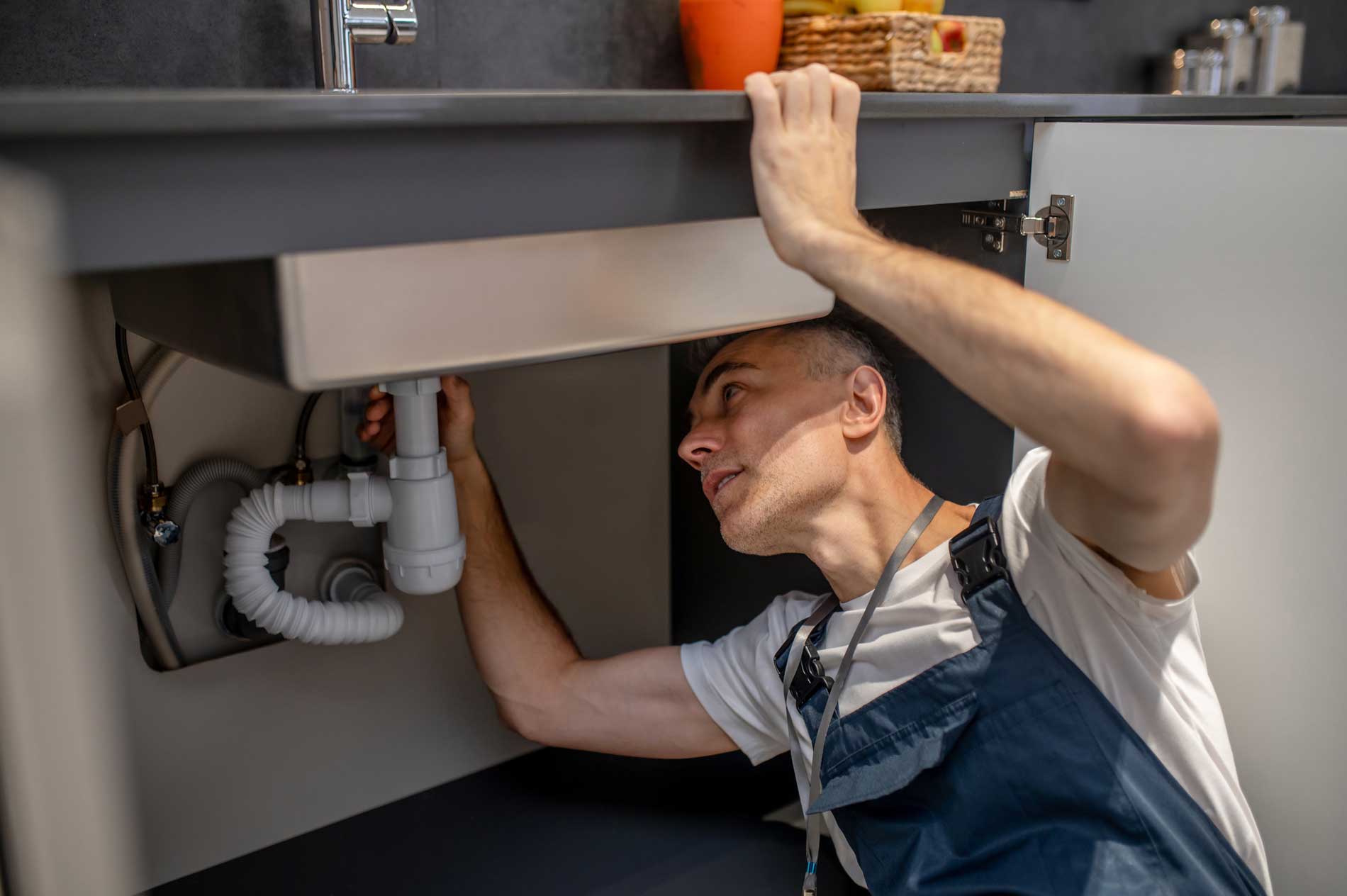 plumber-repair-experienced-attentive-middleaged-man-examining-bottom-kitchen-sink image