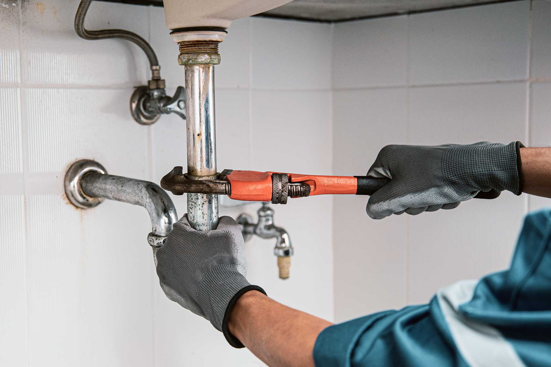 plumber-using-wrench-repair-water-pipe-sink image